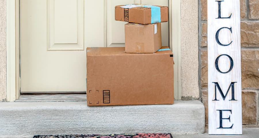 Packages on the doorstep of a home with a welcome sign in New Haven